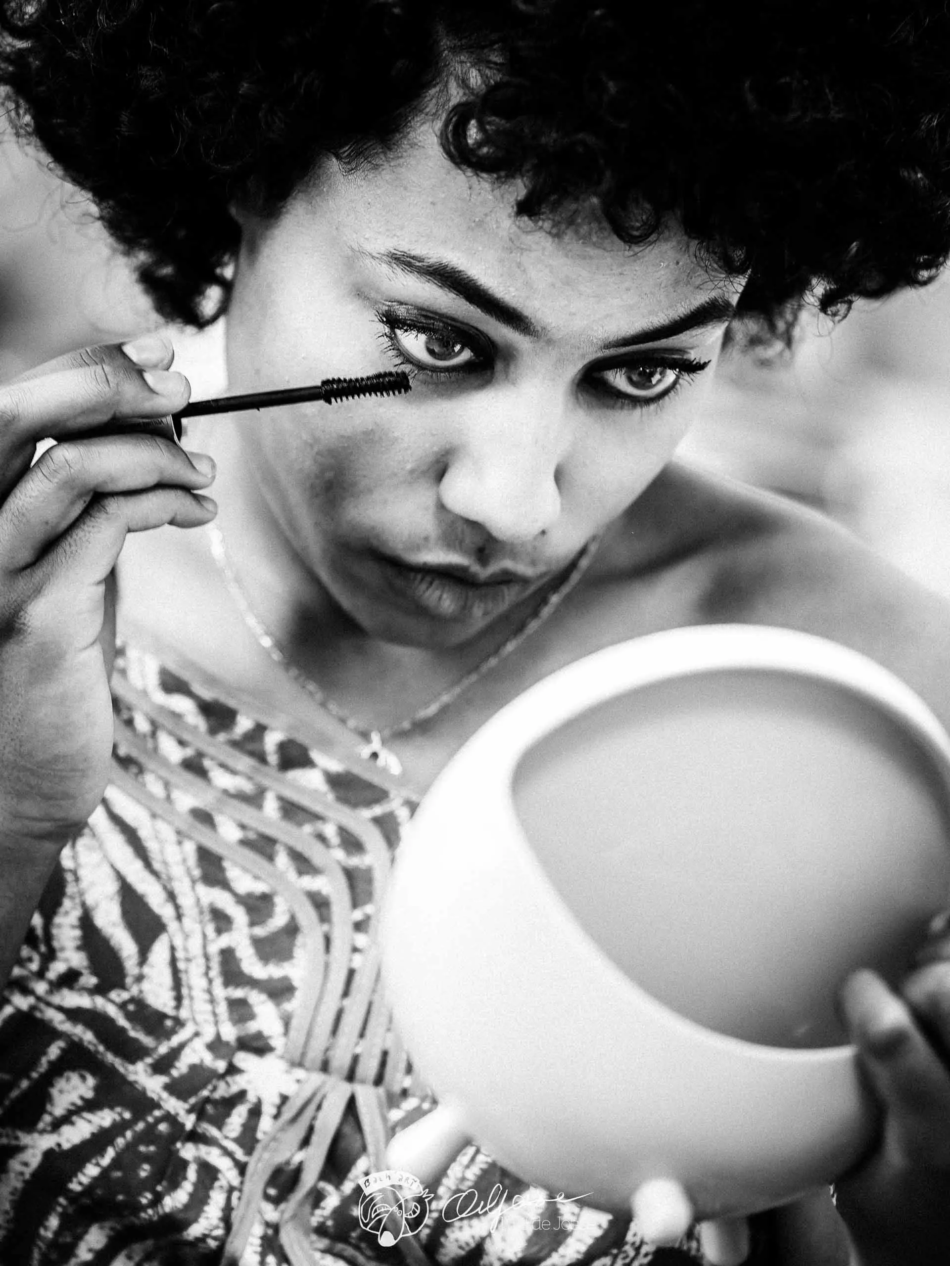 Un comédien applique son mascara face à un miroir.